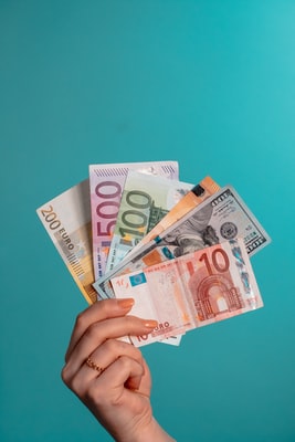 Osoba držící vějíř 100 dolarové bankovky