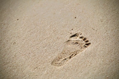 Otisky nohou na bílém písku