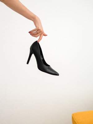 Žena v černých kožených botách na podpatku